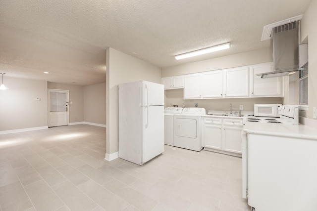 kitchen featuring white appliances, exhaust hood, a textured ceiling, white cabinetry, and washing machine and clothes dryer