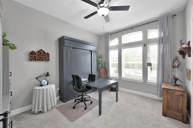 carpeted office space featuring ceiling fan