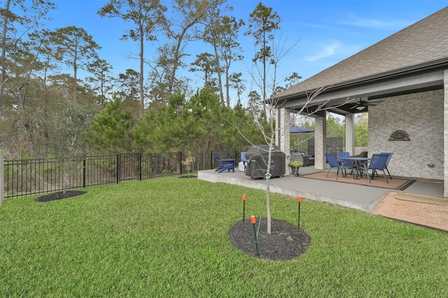 view of yard with ceiling fan and a patio