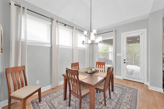 dining space featuring light wood-type flooring and a chandelier