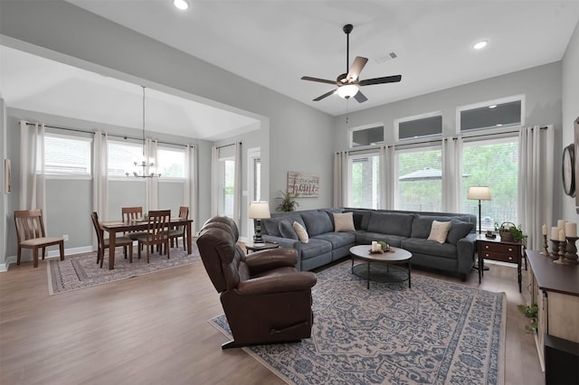 living room with wood-type flooring and ceiling fan with notable chandelier