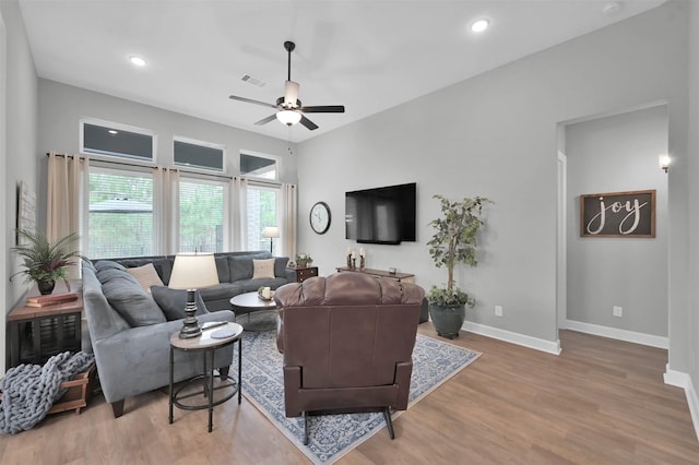 living room featuring light hardwood / wood-style flooring and ceiling fan