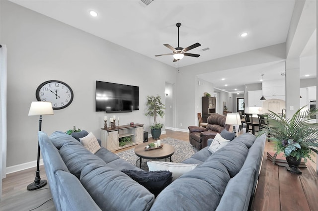 living room with light hardwood / wood-style flooring and ceiling fan