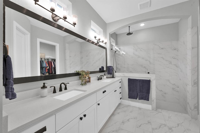 bathroom featuring a tile shower and vanity