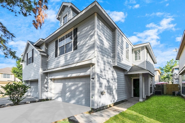 front facade featuring cooling unit, a front yard, and a garage