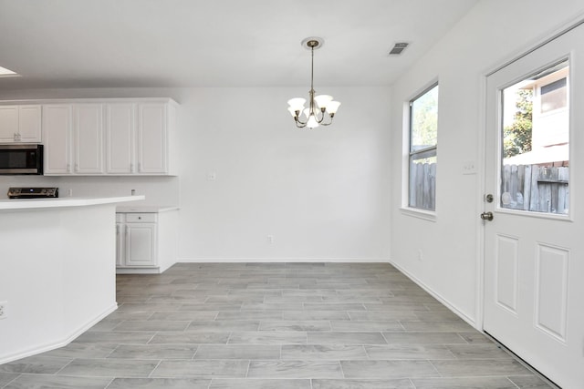 unfurnished dining area featuring a notable chandelier