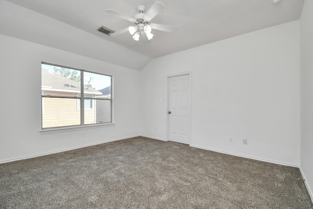 spare room with dark carpet, ceiling fan, and lofted ceiling