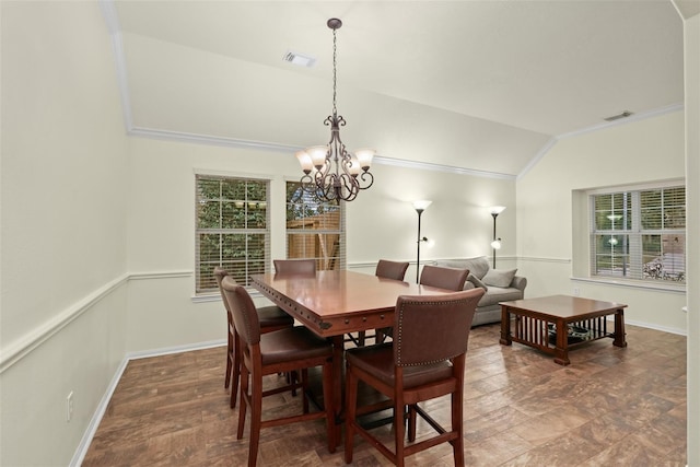 dining space featuring vaulted ceiling, ornamental molding, and an inviting chandelier