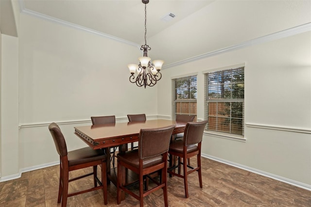 dining area with lofted ceiling, crown molding, and an inviting chandelier