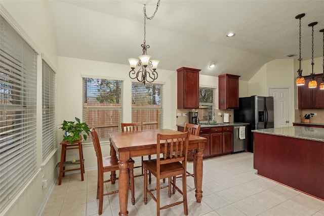 tiled dining room with lofted ceiling, sink, and a chandelier