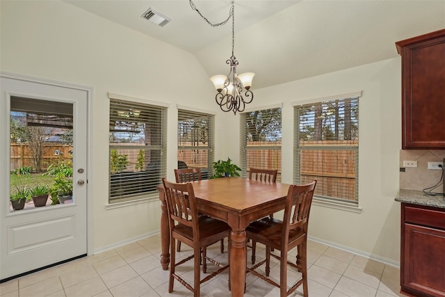 dining space with light tile patterned floors, vaulted ceiling, and a notable chandelier