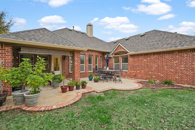 rear view of house with a patio area and a lawn