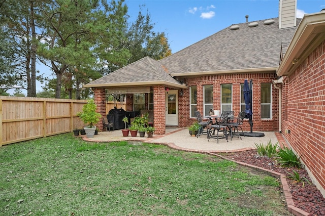 back of property featuring a lawn and a patio