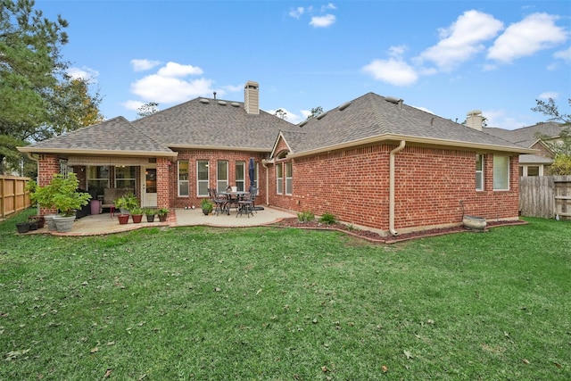 rear view of property with a lawn and a patio area