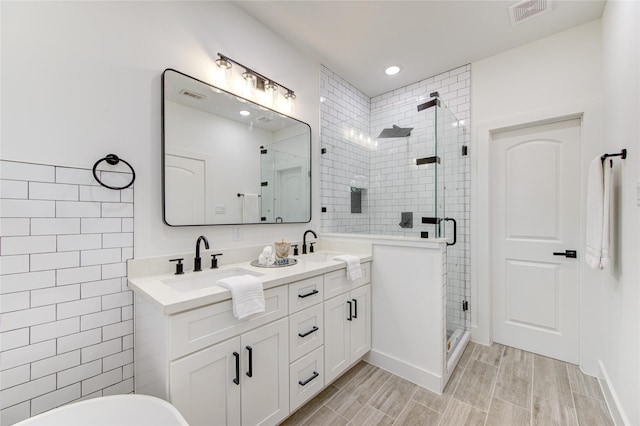 bathroom featuring vanity, a shower with shower door, and tile walls