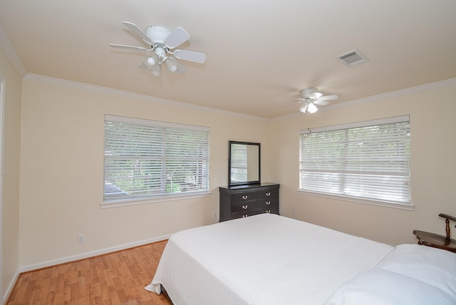 bedroom featuring ceiling fan, light hardwood / wood-style floors, and ornamental molding