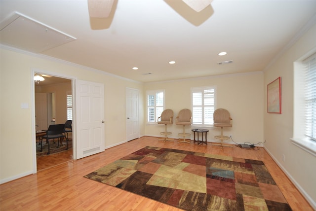 sitting room with hardwood / wood-style floors, ceiling fan, and crown molding