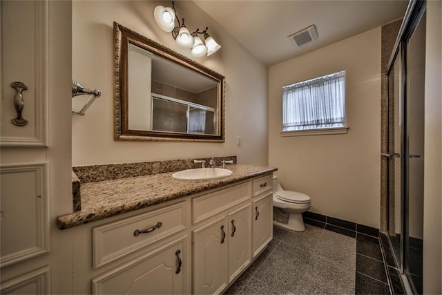 bathroom with tile patterned floors, vanity, toilet, and a shower with door