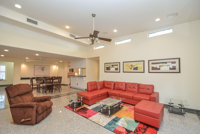 living room featuring ceiling fan and a towering ceiling