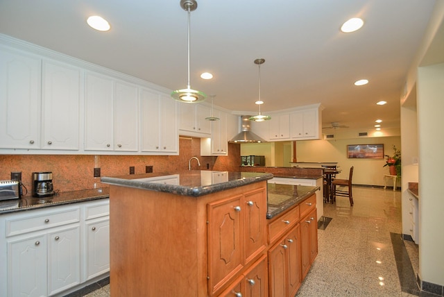 kitchen featuring white cabinetry, a kitchen island, hanging light fixtures, and ceiling fan