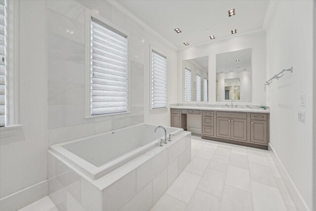 bathroom with tile patterned floors, vanity, a relaxing tiled tub, and crown molding