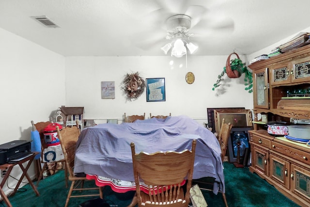 dining area with visible vents, dark carpet, and ceiling fan