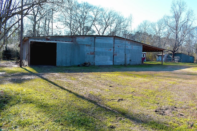 view of pole building with driveway and a yard