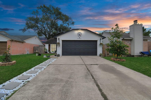 ranch-style house featuring a lawn and a garage