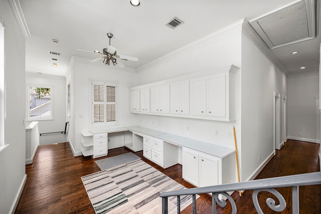 office area featuring crown molding, ceiling fan, dark wood-type flooring, and built in desk