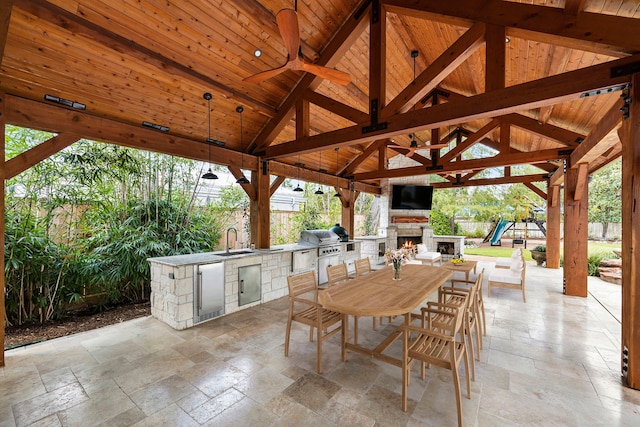 view of patio featuring sink, a gazebo, an outdoor stone fireplace, ceiling fan, and area for grilling