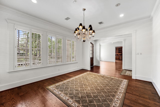 unfurnished dining area featuring dark hardwood / wood-style floors, crown molding, and an inviting chandelier