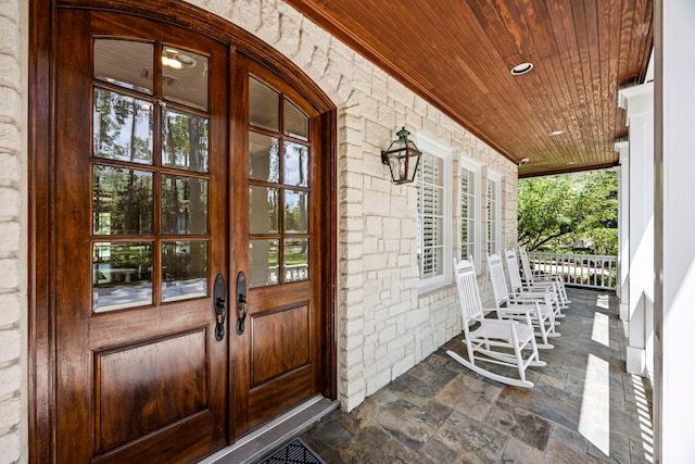 doorway to property featuring a porch and french doors