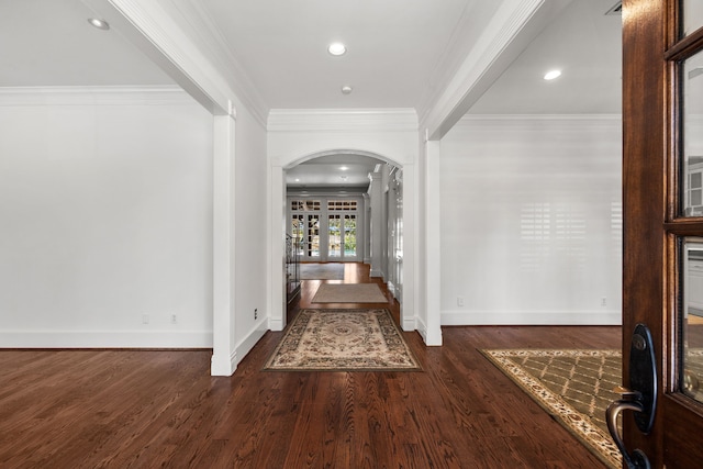 entryway with dark wood-type flooring and crown molding