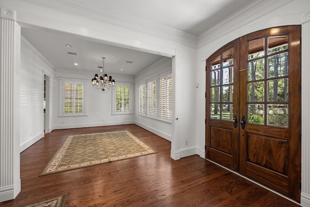 entryway with french doors, dark wood-type flooring, ornamental molding, and a notable chandelier