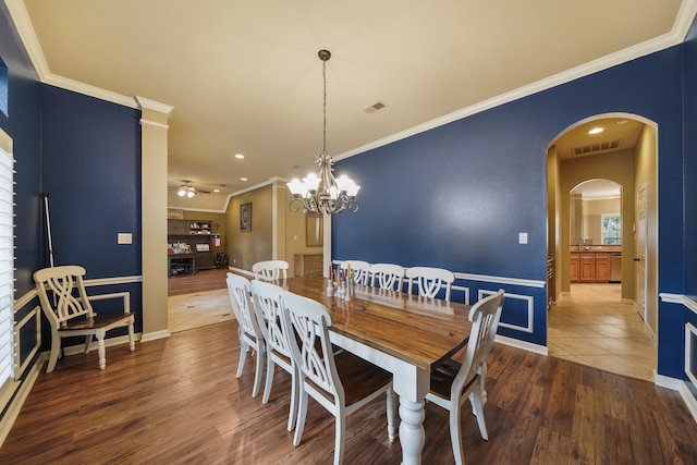 dining room with ornamental molding, ceiling fan with notable chandelier, and hardwood / wood-style flooring