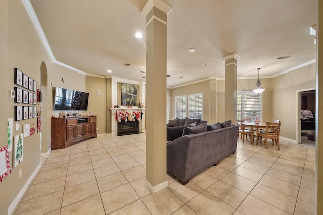 tiled living room featuring ornate columns, an inviting chandelier, and ornamental molding