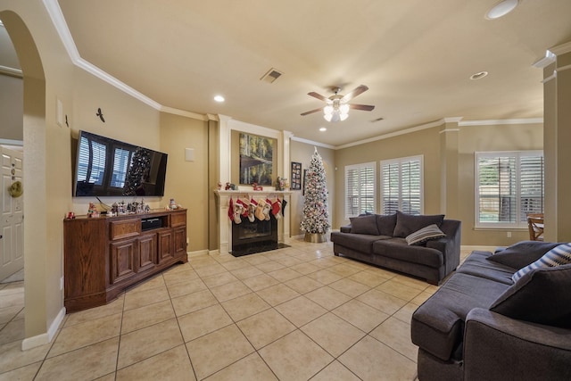 living room with ceiling fan, light tile patterned floors, and crown molding