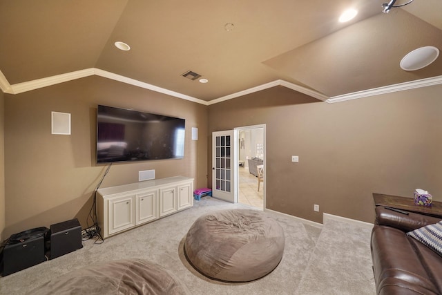 carpeted home theater room with french doors, vaulted ceiling, and crown molding