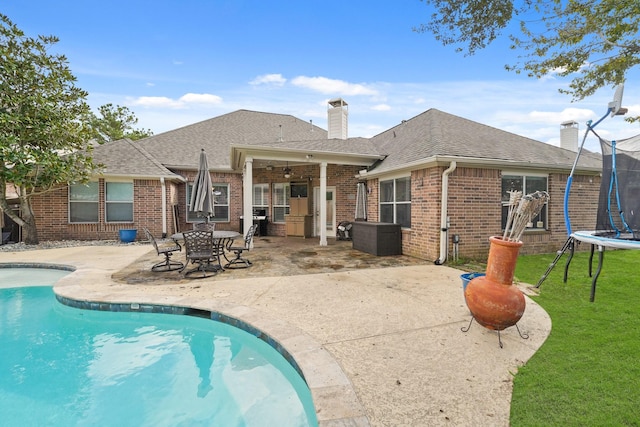 view of pool with a trampoline and a patio