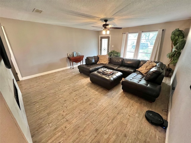 living room featuring ceiling fan, a textured ceiling, and hardwood / wood-style flooring