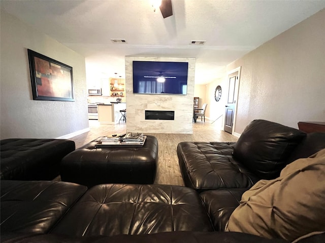 living room featuring light wood-type flooring and a premium fireplace