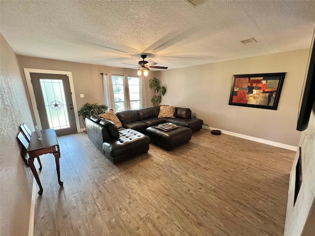 living room with hardwood / wood-style floors, a textured ceiling, and ceiling fan