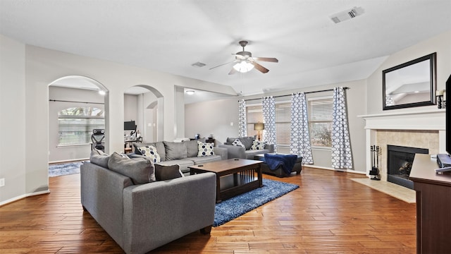 living room with a tiled fireplace, ceiling fan, and hardwood / wood-style floors