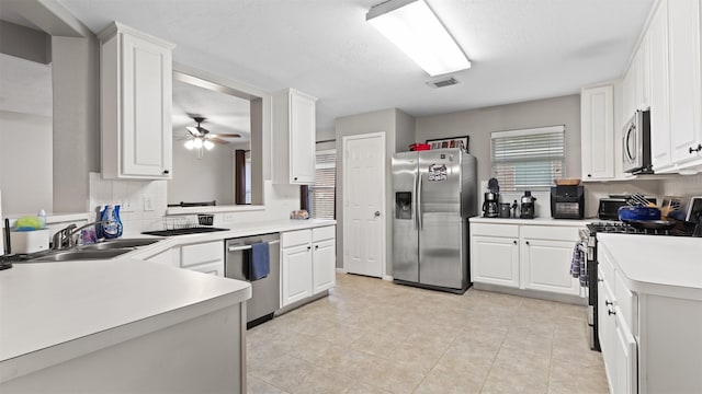 kitchen featuring ceiling fan, sink, white cabinets, and stainless steel appliances