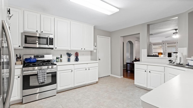 kitchen with ceiling fan, white cabinetry, sink, and appliances with stainless steel finishes