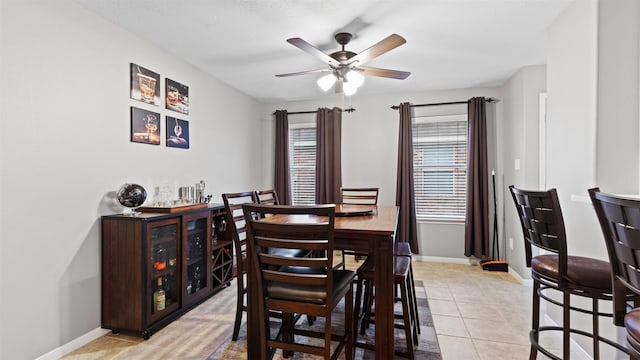 tiled dining space with ceiling fan