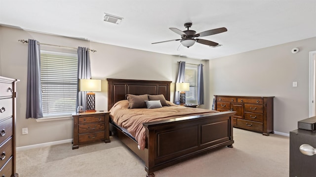 carpeted bedroom featuring multiple windows and ceiling fan