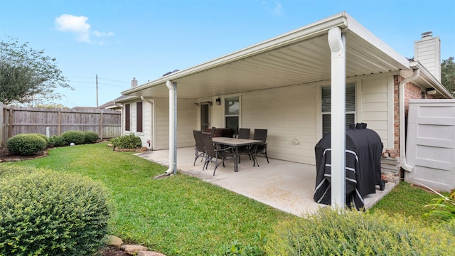 back of property with a yard and a patio