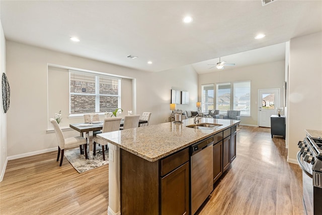 kitchen featuring appliances with stainless steel finishes, dark brown cabinetry, a kitchen island with sink, sink, and light hardwood / wood-style floors