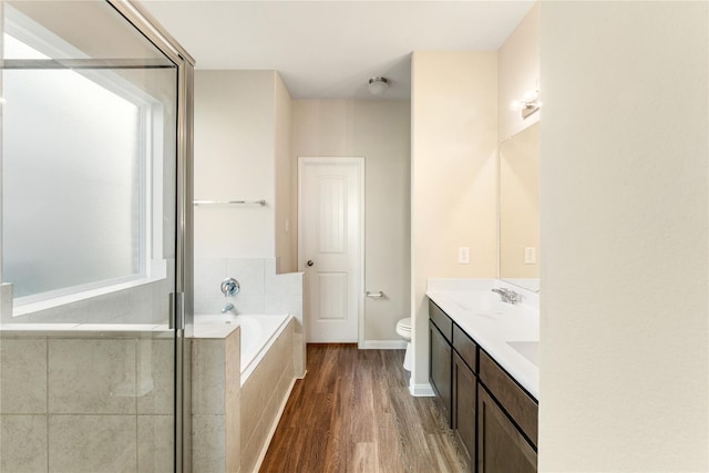 full bathroom featuring plus walk in shower, wood-type flooring, vanity, and toilet